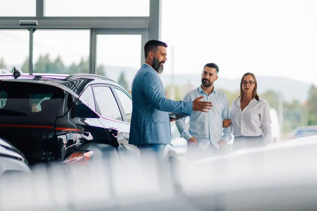 Couple and dealer discussing car options in dealer